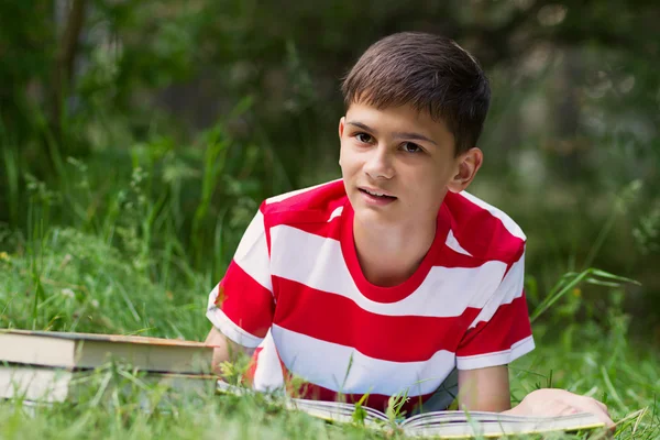 Boy reading a book on grass — Stock Fotó