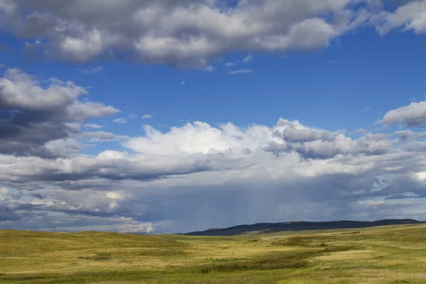 Hilly valley, meadows, pastures and cloudy sky — Stock Photo, Image