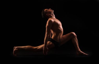 Pratik yoga ve jimnastik siyah bir zemin üzerine