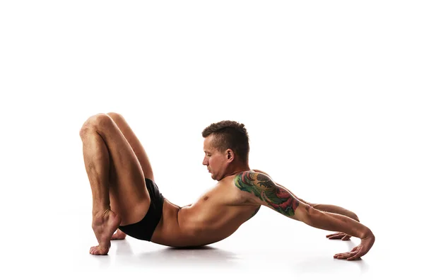 Joven hombre fuerte haciendo yoga y gimnasia —  Fotos de Stock