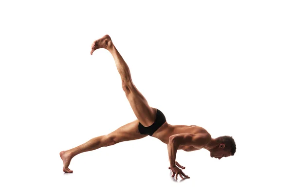 Joven hombre fuerte haciendo yoga y gimnasia, entrenamiento de fuerza —  Fotos de Stock