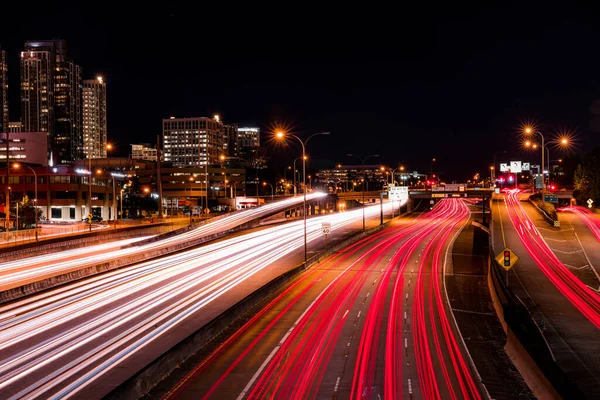Trafiğin yoğun olduğu bir saatte gecenin karanlığında otoyolda uzun süre kalmak. Şehir manzarası arkaplanı.
