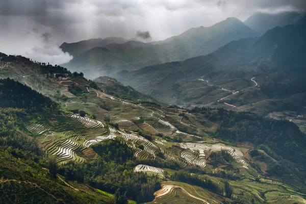 Kuzey Vietnam Pirinç Tarlaları, aşağıdaki geniş pirinç tarlalarını aydınlatan ışık patlamalarıyla kasvetli bir gün.
