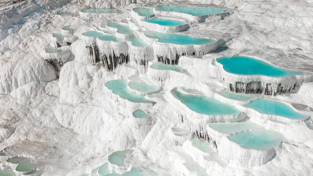 Aerial of the famous Pamukkale travertines in central western turkey. Famous for their turquoise thermal pools and pure white carbon deposits angle 2