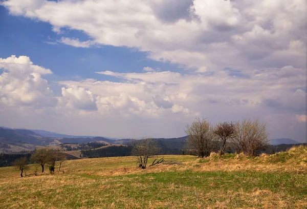 Sunny spring in mountain village. Fields and hills