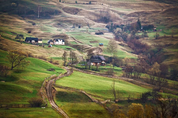 Mattinata di primavera nebbiosa nel villaggio di montagna. Campi e colline — Foto Stock