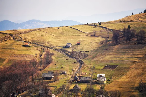 Primavera ensolarada na aldeia de montanha. Campos e colinas — Fotografia de Stock