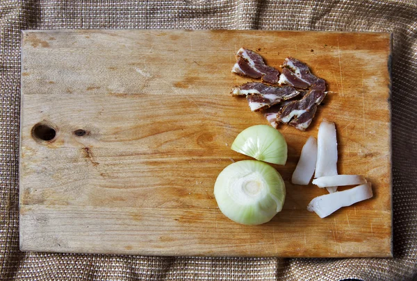 Carne de sal e ingredientes para cozinhar em torno de tábua de corte no ru — Fotografia de Stock