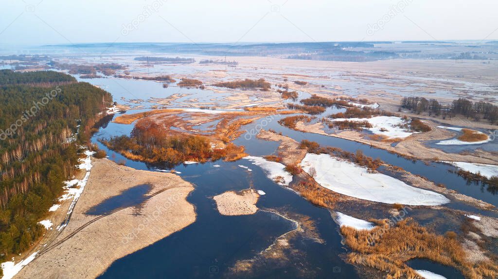 Spring melting river flood aerial panorama. Overflow water at springtime. Rural sunrise landscape. Meadows covered by water. Morning flood-land near Neman, Belarus. 