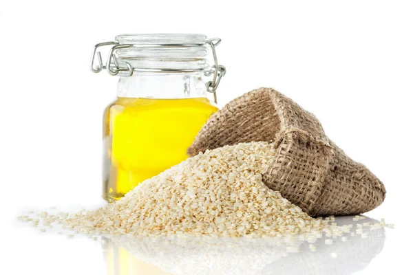 Sesame oil in a transparent glass jug and sesame — Stock Photo, Image