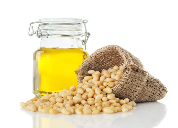 Aceite de cedro en un frasco de vidrio y piñones pelados — Foto de Stock