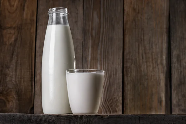 Bir şişe ve cam doğal tam yağlı süt — Stok fotoğraf