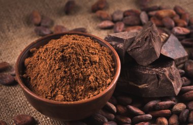 Raw cocoa beans, clay bowl  with cocoa powder, chocolate on sack clipart