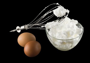 siyah arka plan üzerine izole yumurta ve yumurta çırpma teli ile kırbaçlanan