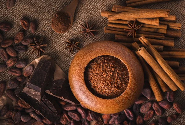 Granos de cacao crudos, delicioso chocolate negro, palitos de canela, sta —  Fotos de Stock
