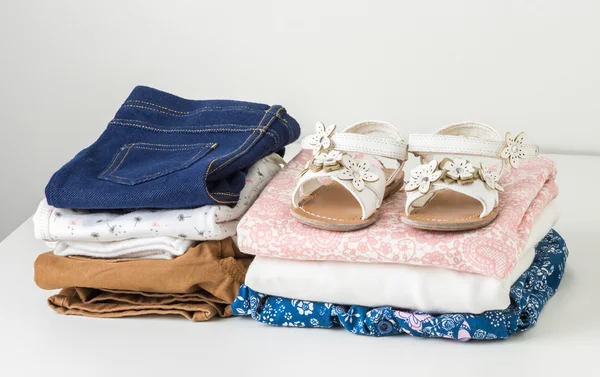 Stack of clean baby clothes in white wardrobe — Stock Photo, Image