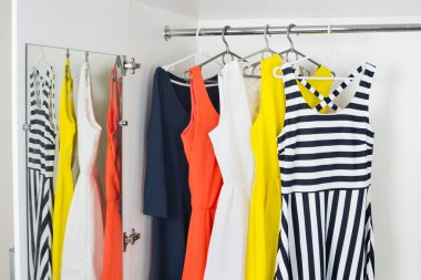 series of bright modern fashion women dresses on hangers