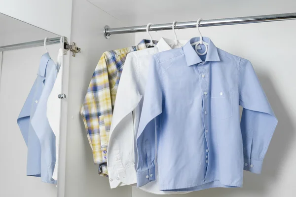 Белые голубые и клетчатые чистые гладильные рубашки мужчин — стоковое фото