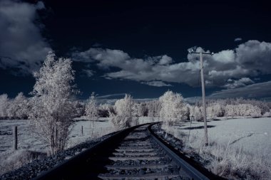 Demiryolu ve mavi bulutlu gökyüzü manzaralı.