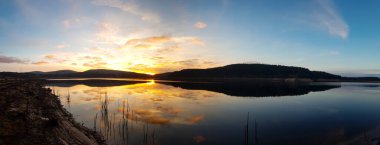 Gün batımı bulutlu gölet manzarası