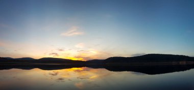 Gün batımı bulutlu gölet manzarası