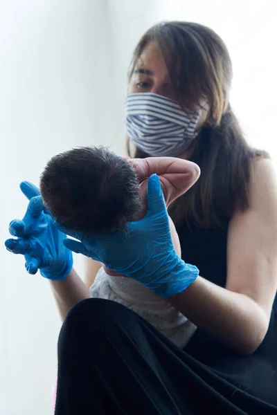 Young female doctor helping newborn baby and testing