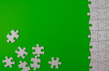 Yeşil arka planda beyaz bulmaca. Rastgele ve tamamlanmamış bir kavram. Boş kopyalama alanı..