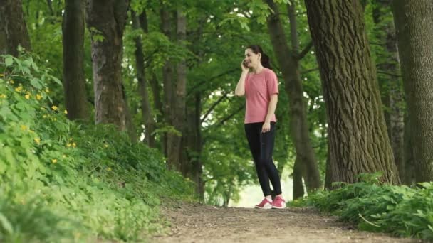 Ragazza che parla da cella nel parco — Video Stock