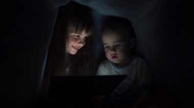 Kız ve oğlan okuma kitabı battaniyenin altında