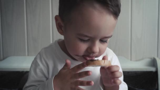 Malý chlapec legrační jí chleba s máslem — Stock video
