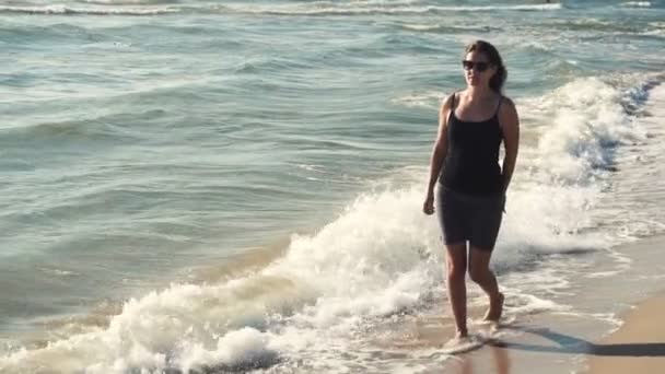 Chica atractiva en la costa en gafas de sol — Vídeos de Stock