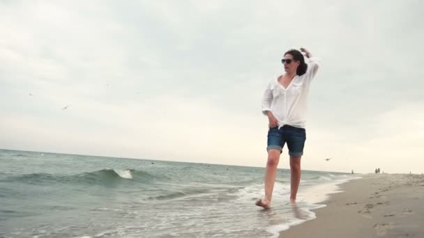 Aantrekkelijk meisje op de zeekust in zonnebril — Stockvideo