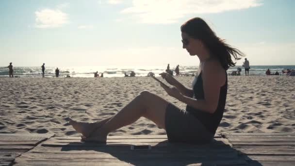Dziewczyna na plaży z komputera typu tablet — Wideo stockowe