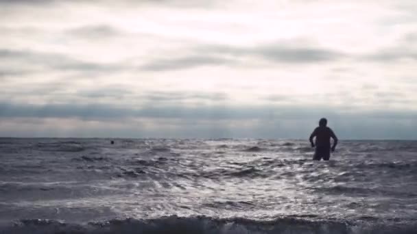 Senior man binnenkomt zee golven — Stockvideo