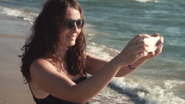 Aantrekkelijk meisje maakt selfie op de zeekust — Stockvideo