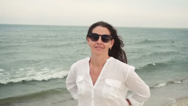 Vonzó lány a tengerparton napszemüveg — Stock videók