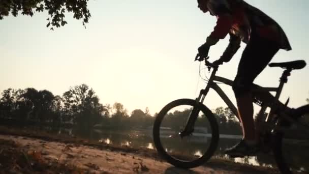 Mann fährt Fahrrad in der Nähe des Sees — Stockvideo