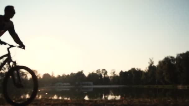 L'uomo guida una bicicletta vicino al lago — Video Stock