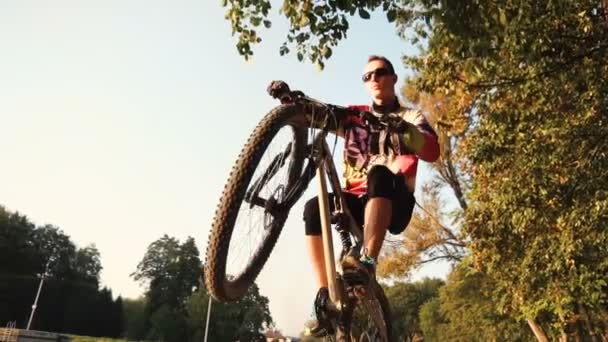 Man rijdt een fiets in de buurt van lake — Stockvideo