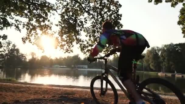 Uomo saltare in bicicletta vicino al lago — Video Stock