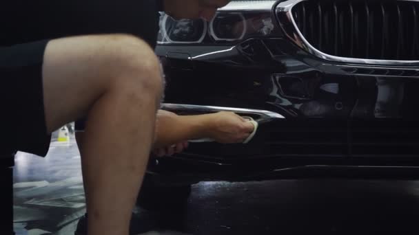Mekaniker polering ansikte lyx mörk bil i tjänst — Stockvideo
