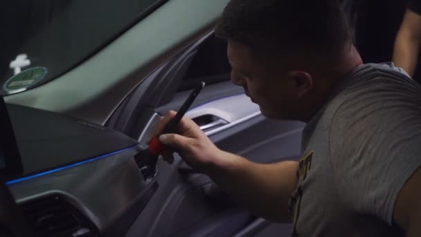 Bil ekspert bruger børste til rengøring køretøj inde – Stock-video