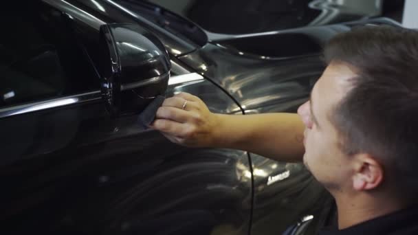 Otomobil servis çalışanı araba yüzeyini cilalamak için sünger kullanıyor — Stok video