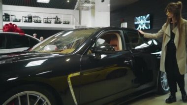 Galeride modern arabanın yeni modelini seçen şık bir kadın.