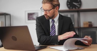 Karmaşık adam dizüstü bilgisayardaki raporu tekrar kontrol ediyor