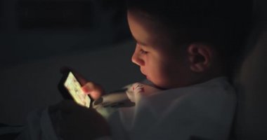 Küçük çocuk akıllı telefonda oyun oynuyor.