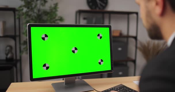 Бізнесмен дивиться на зелений екран комп'ютера — стокове відео