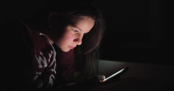 Pretty kid using smartphone in dark — Stock Video