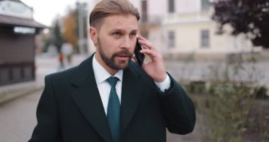 İş adamı sokakta konuşuyor.