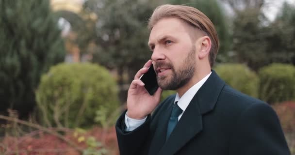 ビジネスマンが屋外でスマートフォンで話している — ストック動画